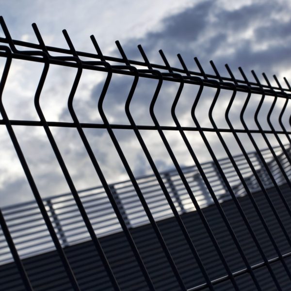 Close up of fences of a prison and cloudy sky on background